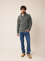 Sweater de polar color beige, con cuello alto y cierre frontal parcial. Presenta un pequeño logo bordado en el pecho.