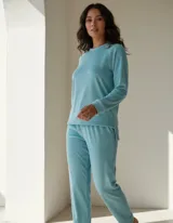 Conjunto de pijama de dos piezas confeccionado en tela de plush térmico color celeste. Incluye una remera de manga larga con cuello redondo y un pantalón de corte recto con cintura elástica.