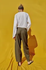 Pantalón de lino marrón oscuro, de corte barrel con pernera holgada que se estrecha hacia el tobillo, cintura elástica y bolsillos delanteros.