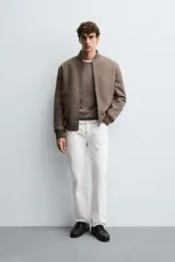 Cazadora bomber marrón con interior efecto pelo, cuello y puños de rib elástico, bolsillos de vivo en cadera, bolsillo interior y cierre frontal con cremallera.