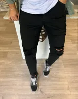 Pantalón jean skinny color negro, con roturas en las rodillas y calce ajustado.