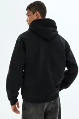 Campera con capucha de felpa de peso medio con interior cepillado suave. Presenta hombros caídos, cierre frontal, bolsillos tipo canguro y terminaciones en punto acanalado en puños y bajo.