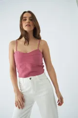 Top corto de dama con tirantes finos ajustables, confeccionado en tejido de textura natural con costuras decorativas en el frente y grifa de cuero.