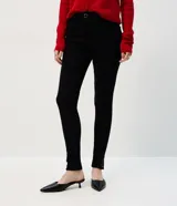 Pantalón de jean modelo skinny con cintura alta, cierre frontal con botón y cremallera, bolsillos funcionales y detalle metálico aplicado en el bajo cerca del tobillo.