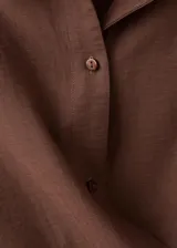 Camisa cruzada de color marrón, con diseño recto, cuello camisero, manga larga y cierre de lazo en la cintura con botones.