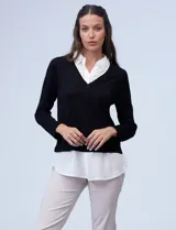 Buzo combinado con torso de tejido de punto fino en color negro y detalles de cuello y ruedo en gasa blanca que simulan una camisa debajo. Presenta escote en V y mangas largas.