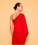 Blusa roja de lino con un solo hombro y manga larga abullonada.