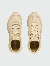 Zapatillas Moncler modelo Pacey 2, confeccionadas en una combinación de nobuk y tejido técnico en color beige. Presentan un diseño con suela dentada, cierre de cordones y el logo de la marca bordado en el lateral.