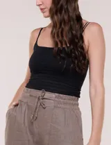 Top crop musculosa Allie Rose de color blanco, confeccionado en tela elastizada con textura en relieve y leve semitransparencia. Cuenta con escote recto, doble bretel fino en cada hombro y silueta entallada al cuerpo.
