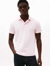 Chomba Tommy Hilfiger color rosado de corte regular, confeccionada en tejido jacquard de mezcla de algodón BCI y poliéster reciclado. Cuenta con cuello tipo chomba, billetera de dos botones, detalles distintivos de la marca y logo bordado en la manga.