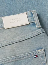 Pantalón de jean celeste de corte recto, con cierre de botón y cremallera, cinco bolsillos y parche de cuero con logo de Tommy Hilfiger en la parte trasera.