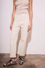 Pantalón de jean color crudo, corte recto, tiro medio, confeccionado en algodón peinado con elastano.