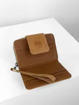 Mini billetera Chabas confeccionada en cuero con detalle frontal en pelo con estampado animal print. Cuenta con solapa de cierre con logo de búho grabado y correa de muñeca extraíble.