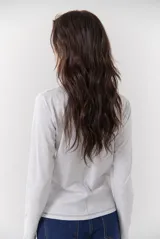 Remera blanca de manga larga con cuello redondo y costuras decorativas en contraste de color negro.