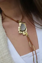 Collar con colgante irregular de bronce con incrustación de nácar y cordón de cuero marrón.