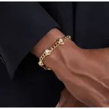 Pulsera dorada con cadena de eslabones gruesos y dijes hexagonales con circonitas blancas.