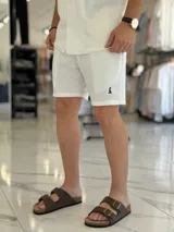 Bermuda blanca de tejido texturizado, con pequeño bordado oscuro en la parte inferior izquierda.