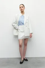 Minifalda de tweed color blanco con flecos en el ruedo.