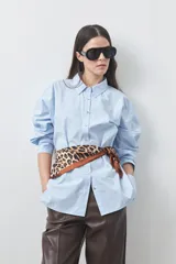 Camisa de manga larga de algodón en color blanco, con cuello clásico, cierre frontal de botones y silueta relajada.
