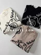 Sweater de tejido de punto con cuello redondo y diseño de bordado lineal en contraste que forma motivos orgánicos y florales. Presenta un corte clásico y mangas largas.