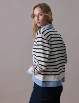 Campera combinada marca Nanette, con torso y mangas en tejido a rayas horizontales blancas y negras. Solapa, puños y cierre en denim celeste. Cierre frontal con botones metalizados.