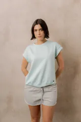 Sweater de punto color blanco, de corte relajado, con cuello redondo, manga corta japonesa de hombro caído y pretina ancha en la cintura.
