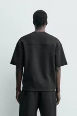 Sudadera de manga corta con corte relajado, confeccionada en tejido interlock de algodón con elasticidad y cuello redondo.