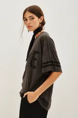Remera de algodón y modal con cuello redondo, mangas cortas con detalle de rayas laterales y estampa frontal con la palabra LOVE bordada en lentejuelas.