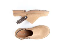 Zuecos de cuero color beige, con suela track y tira trasera ajustable.