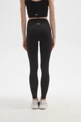 Calza deportiva de poliamida, color negro, con diseño al cuerpo y cintura alta.
