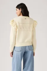 Sweater de punto color crema, con cuello redondo y calado en el frente, mangas largas con volados en los hombros y puños acanalados.