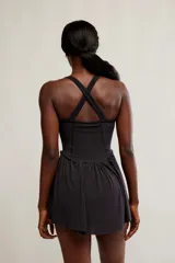 Vestido corto deportivo negro con efecto smock en el torso, tirantes finos blancos y falda de vuelo suave.