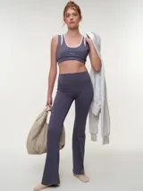 Calza larga flare de cintura alta, color gris oscuro, con diseño ajustado en las piernas y botamanga amplia.