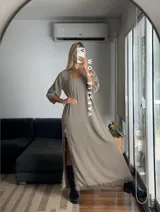 Vestido largo negro de tela de Cey, con escote en V, mangas largas abullonadas, tajo lateral con detalle de encaje y ruedo con encaje.