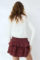 Saco ajustado de punto acanalado fino marca H&M Divided, color blanco, con cuello redondo y cierre frontal de botones. Presenta ribetes de volados en el escote, la tapeta y el bajo.