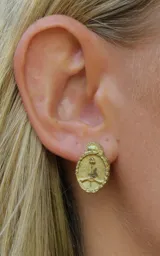 Par de aros plateados con forma de escudo y diseño abstracto en relieve.