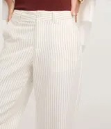 Pantalón wide leg de sarga color crudo con finas rayas verticales. Tiene cintura media con trabillas, bolsillos laterales y traseros.