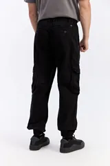 Pantalón cargo color tostado de corte amplio, con cintura elástica y cordón ajustable. Cuenta con bolsillos laterales con tapa en las piernas y puños elastizados en los tobillos.