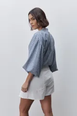 Short pollera de tiro alto confeccionado en algodón, con diseño cruzado en el delantero que simula una falda, cierre lateral invisible y bolsillos traseros.