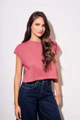 Remera gris de algodón con poliéster, corte crop, mangas cortas y bolsillo en el pecho.