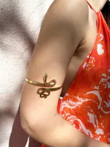 Brazalete dorado para el brazo, con diseño de serpiente enroscada.