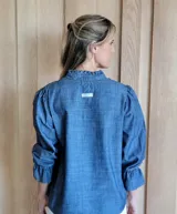 Blusa de algodón con cuello mao y volados, mangas largas con puños elásticos y corte holgado.