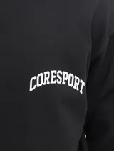 Buzo negro de manga larga con cuello redondo y calce oversize cropped. Presenta un estampado grande en la espalda con texto en blanco que incluye "CORE", "1990", "Functional Aesthetics", "CoreSport©" y tres estrellas.