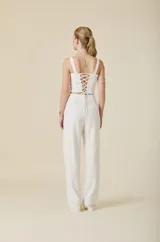 Pantalon de tiro alto y corte recto, confeccionado en encaje con detalles de crepé sastrero en la cintura. Presenta un diseño sofisticado con cierre invisible en la espalda.