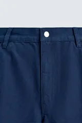 Bermuda cargo de corte relajado confeccionada en tejido de algodón. Presenta bolsillos laterales tipo cargo con solapa, bolsillos frontales y cierre frontal con cremallera y botón. Incluye detalles bordados a tono en la pernera.