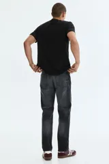 Pantalón jean de cinco bolsillos en denim de algodón con lavado negro y efecto deslavado. Presenta un corte regular de pierna recta y tiro medio con cierre frontal de botón y cremallera.