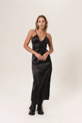 Vestido midi negro de satén con breteles finos, escote en V con volados y lazo ajustable.
