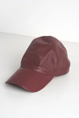 Gorra con visera confeccionada en cuero, con diseño clásico de seis paneles y cierre ajustable en la parte posterior.
