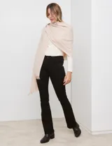 Bufandón tejido de poliéster, color rosa pálido con textura jaspeada en tonos pastel (naranja, lila, gris). Presenta un tejido grueso y flecos en los bordes.