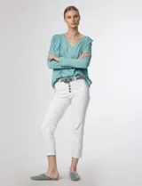 Blusa verde pastel con escote en V, cierre frontal con botones y volados con detalles calados en el frente y las mangas.